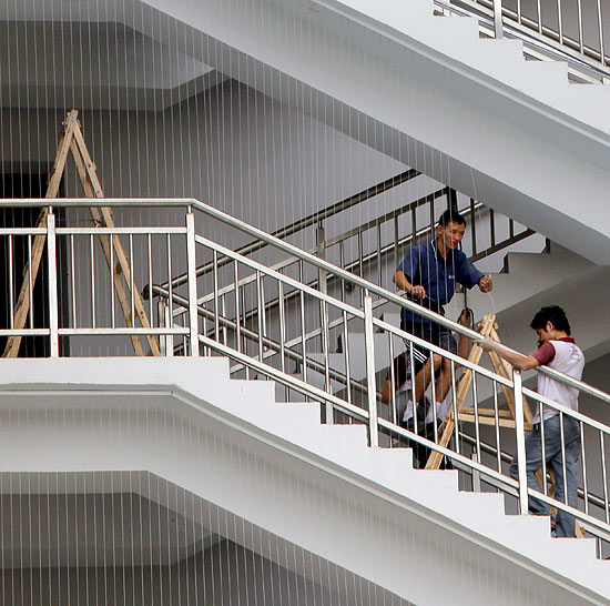 Funcionários instalam grades em fábrica da Foxconn na China, após onda de suicídios