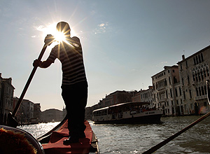 Gondoleiro manobra no canal de Veneza, na Itália
