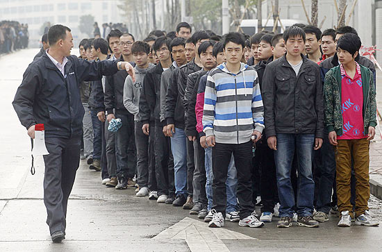 Candidatos a trabalhar na Foxconn, fornecedora da Apple, fazem fila em Shenzhen, na China