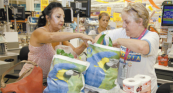 Cliente recebe sacola reutilizvel em supermercado de So Paulo