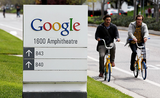 Pessoas passeiam de bicicleta em frente  sede do Google; empresa pode pagar multa sob novas regras da UE
