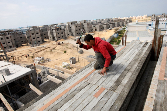 Palestino trabalha na construção de projeto residencial patrocinado pela ONU, em Rafah, no sudeste da faixa de Gaza