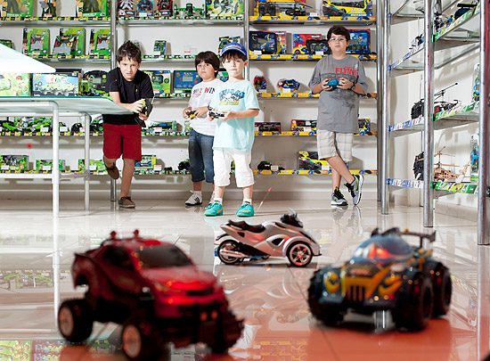 Meninos pilotam carros de controle remoto em loja em SP; Natal é a segunda data mais importante para o setor