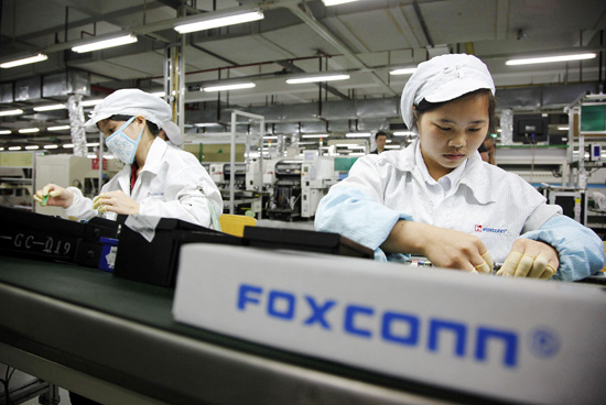 Funcionários trabalham em linha de montagem de fábrica da Foxconn em Shenzhen, Guangdong, na China