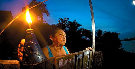 Maria Assuno, 74, com a lamparina que usa  noite em sua casa, s margens do lago da maior hidreltrica 100% em territrio nacional, Tucuru (PA)
