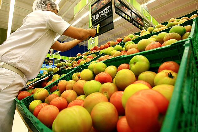 Funcionário corrige o preço de produtos na banca de tomates em supermercado na cidade de Ribeirão Preto (SP)