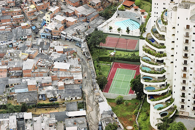 Vista do bairro do Morumbi, em São Paulo (SP), mostra prédio de apartamentos de luxo que faz divisa com a favela de Paraisópolis.