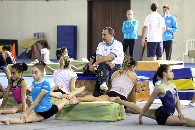 Oleg Ostapenko, sentado, acompanha treino de ginastas