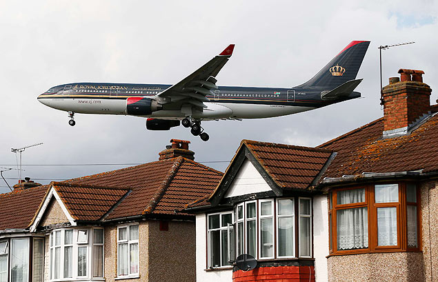 ORG XMIT: SWT07 A Royal Jordanian airways jet arrives over the top of houses to land at Heathrow Airport in west London August 28, 2012. Britain's transport minister said on Tuesday she would probably resign if the government gave in to pressure to expand London's Heathrow airport. Conservative Prime Minister David Cameron's government has ruled out building a third runway at Heathrow before the next election, in part to appease the junior coalition partner, the Liberal Democrats, but the issue has returned to the agenda with the economy still stuck in recession. REUTERS/Stefan Wermuth (BRITAIN - Tags: BUSINESS TRAVEL POLITICS TRANSPORT)