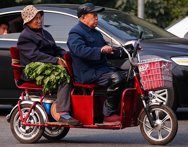 Casal de idosos em triciclo nas ruas de Pequim; maior parte da população da China não tem aposentadoria