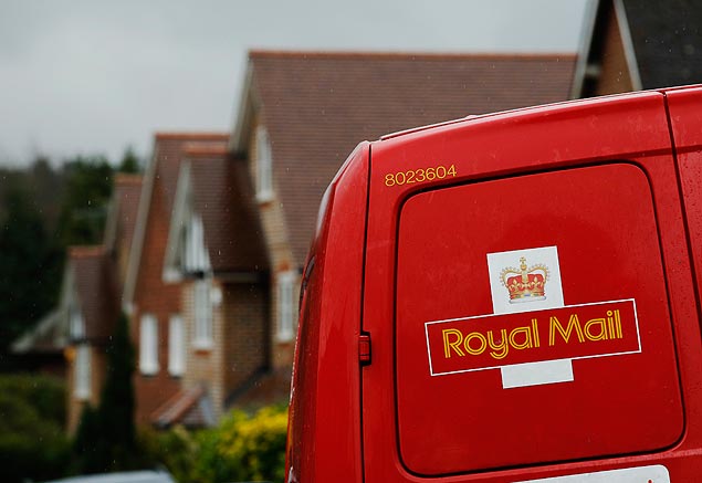 A Royal Mail postal van is parked outside homes in Maybury near Woking in southern England March 25, 2014. Britain's newly-privatised postal operator Royal Mail said on Tuesday it would cut around 1,300 operational and head office jobs in order to deliver annualised savings of 50 million pounds ($82.45 million). REUTERS/Luke MacGregor (BRITAIN - Tags: BUSINESS POLITICS EMPLOYMENT) ORG XMIT: LON102