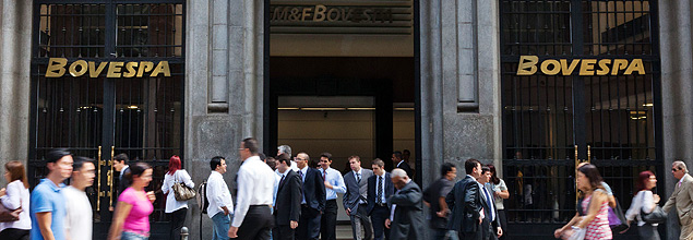 Pessoas passam em frente ao prdio da BM&FBovespa, em So Paulo. *** People walk past the front of Sao Paulo's Stock Exchange (Bovespa) in Sao Paulo, Brazil, ychon August 8, 2011. The Sao Paulo stock exchange, South America's largest, had plummeted 5.33 percent by midday Monday as world stocks slid in volatile trading, officials said. The Bovespa bourse dropped to 50,128 points after opening 4.5 percent down amid fears over the eurozone crisis and after Standard and Poor's stripped the US economy of its triple-A rating for the first time ever on Friday, downgrading it to AA+. AFP PHOTO/Yasuyoshi CHIBA