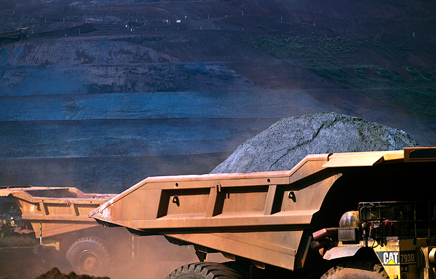 Caminhões basculantes carregam minério de ferro de mina da Vale em MG