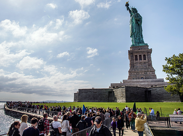The Statue of Liberty looms over crowds of visitors on Liberty Island in New York Harbor, Sunday, Oct. 13, 2013, in New York. The Statue of Liberty reopened to the public after the state of New York agreed to shoulder the costs of running the site during the partial federal government shutdown. (AP Photo/John Minchillo) ORG XMIT: NYJM113