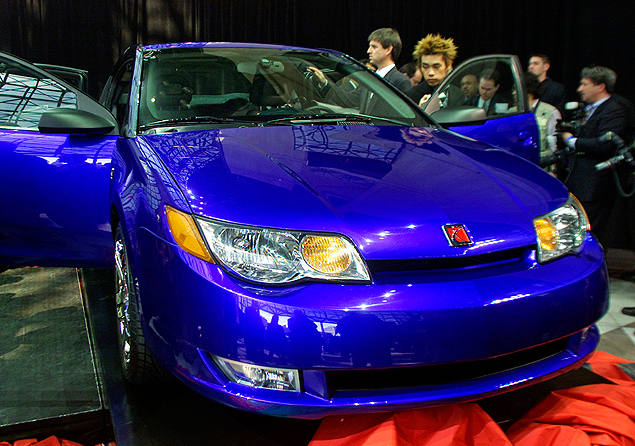 Members of the press view the new 2003 Saturn ION quad coup at its debut at the New York International Auto Show in New York in this file photo taken March 27, 2002. The 2003 Saturn Ion was supposed to be a watershed car for General Motors Co. Instead, it came to represent the compromises and corner cutting that almost destroyed GM and now find the company facing a global recall of some of its most popular models. REUTERS/Peter Morgan/Files (UNITED STATES - Tags: TRANSPORT BUSINESS) ORG XMIT: TOR900