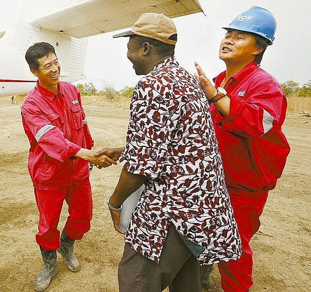 Trabalhador chins cumprimenta trabalhador africano, em uma usina petrolfera, no Chade
