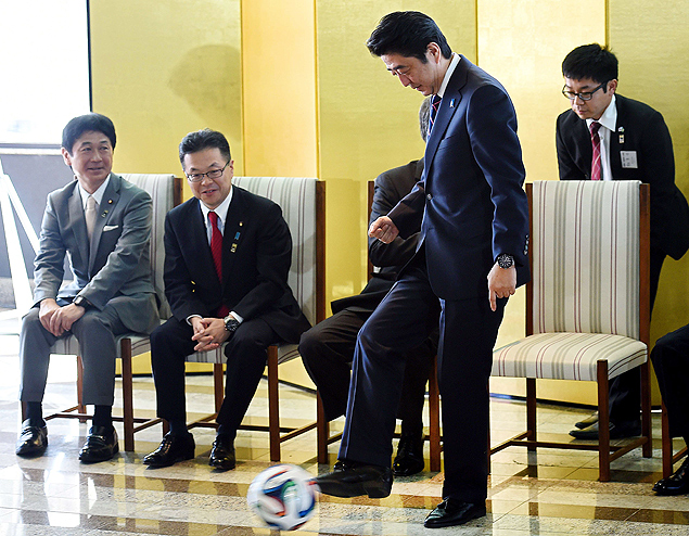 O primeiro-ministro do Japo, Shinzo Abe, brinca com bola de futebol usada na Copa durante encontro com empresrios brasileiros