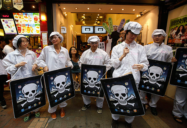 Estudantes chineses protestam vestidos de trabalhadores da Foxconn em frente à loja que revende produtos Apple