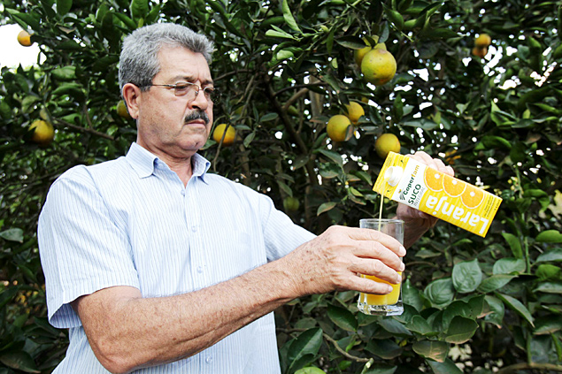 O produtor Arnaldo Hernandez serve suco das laranjas de seu pomar em Bebedouro (SP)