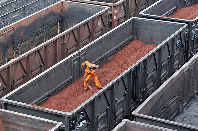 Trabalhador chins retira ferro no porto de Yingkou, na China, um dos maiores portos do pas; *** A worker shovels iron ore on a hopper car at Yingkou port, one of China's biggest ports for importing the commodity, in Liaoning province, in this March 22, 2010 file photo. China's imports of iron ore in August rose 7.9 percent from the previous month to a three-month high with buyers turning to the international market as a collapse in prices forced domestic producers to slash output. REUTERS/Sheng Li/Files (CHINA - Tags: BUSINESS COMMODITIES) CHINA OUT. NO COMMERCIAL OR EDITORIAL SALES IN CHINA
