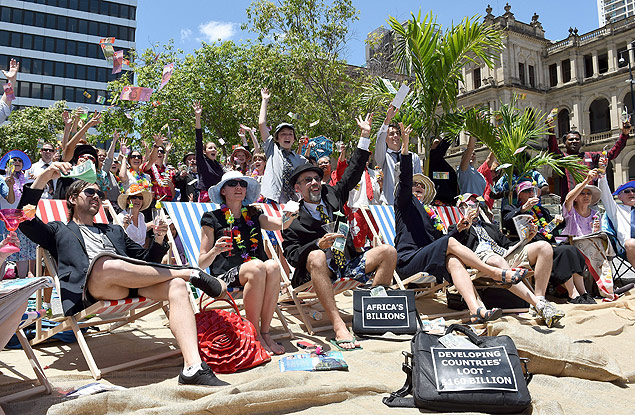 Simulando uma praia em paraíso fiscal, manifestantes protestam contra o G20 em Brisbane