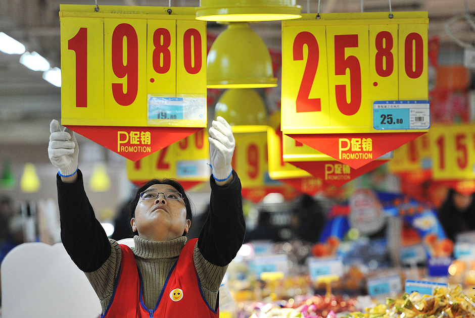 Funcionria altera preos em supermercado de Hefei, provncia de Anhui, na China; inflao ao consumidor foi de 2% em 2014