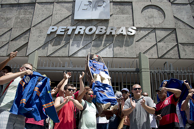 Workers from a company that works under contract for the Brazilian state-owned oil company Petrobras carry a coffin with a dummy representing its president Maria das Gracas Foster during a protest in front of the Petrobras building in Rio de Janeiro, Brazil, on January 29, 2015. The demonstrators demand the payment of three months of wages in arrears. AFP PHOTO/VANDERLEI ALMEIDA ORG XMIT: VAN096
