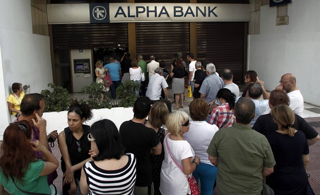 Gregos fazem fila para retirar dinheiro em caixa eletrnico em Atenas, em foto de junho