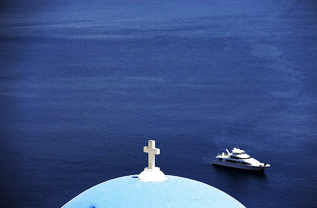 Um iate  visto no horizonte na vila de Oia, na ilha grega de Santorini