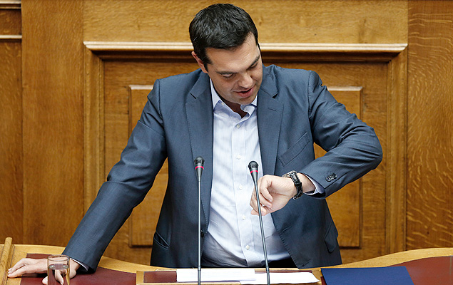 Greek Prime Minister Alexis Tsipras looks at his watch as he speaks to a parliamentary session in Athens, Friday, Aug. 14, 2015. Greek lawmakers approved their country&#146;s draft third bailout in a parliamentary vote Friday that relied on opposition party support and saw the government coalition suffer significant dissent.(AP Photo/Yannis Liakos) ORG XMIT: XPG123