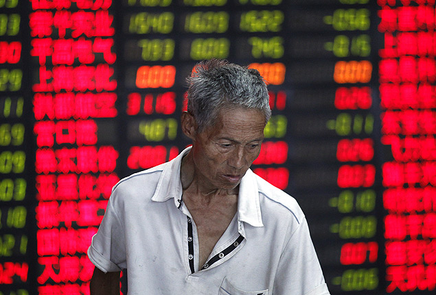 Investidor acompanha os ndices durante o prego da Bolsa de Valores de Xangai (China). *** ORG XMIT: XEH104 An investor looks at the stock price monitor at a private securities company Tuesday, Aug. 9, 2011 in Shanghai, China. Asian stocks markets are stabilizing after a day of dramatic plunges Tuesday as futures point to a measure of calm returning to Wall Street following the Dow's sixth worst decline in the last 112 years. (AP Photo/Eugene Hoshiko)