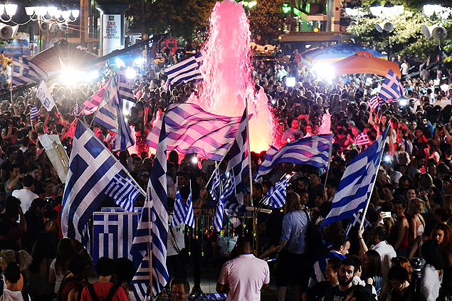 People celebrate in Athens on July 5, 2015 after the first exit-polls of the Greek referendum. Over 60 percent of Greeks rejected further austerity dictated by the country's EU-IMF creditors in a referendum, results from 20 percent of polling stations showed. AFP PHOTO / LOUISA GOULIAMAKI ORG XMIT: LOU1755LEGENDA DO JORNALGregos comemoram resultado do plebiscito neste domingo (5) no centro de Atenas