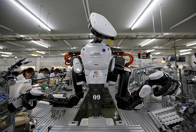 A humanoid robot works side by side employees in the assembly line at a factory of Glory Ltd., a manufacturer of automatic change dispensers, in Kazo, north of Tokyo, Japan, in this July 1, 2015 file photo. Japan is expected to release industrial output numbers this week. REUTERS/Issei Kato/Files GLOBAL BUSINESS WEEK AHEAD PACKAGE - SEARCH "BUSINESS WEEK AHEAD AUG 10" FOR ALL IMAGES ORG XMIT: BWA106