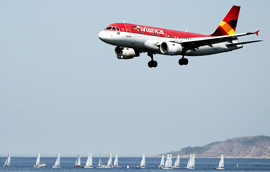 In the forefround an Avianca airliner lands in the Santos Dumont airport (not framed) as sailing boats compete in the International Sailing Regatta held in the Guanabara Bay in Rio de Janeiro, Brazil on August 19, 2015, an event that serves as a test for the Rio 2016 Olympic Games. AFP PHOTO/VANDERLEI ALMEIDA ORG XMIT: VAN971LEGENDA DO JORNALAvio da Avianca pousa no aeroporto de Santos Dumont