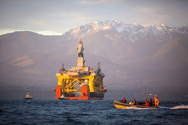 FILE - In this April 17, 2015 file photo, with the Olympic Mountains in the background, a small boat crosses in front of the Transocean Polar Pioneer, a semi-submersible drilling unit that Royal Dutch Shell leases from Transocean Ltd., as it arrives in Port Angeles, Wash., aboard a transport ship after traveling across the Pacific before its eventual Arctic destination. The U.S. government on Monday gave Shell the final permit it needs to drill for oil in the Arctic Ocean off Alaska's northwest coast for the first time in more than two decades. (Daniella Beccaria/seattlepi.com via AP, File) MAGS OUT; NO SALES; SEATTLE TIMES OUT; TV OUT; MANDATORY CREDIT ORG XMIT: WASEA301