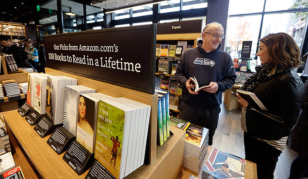 Customer Jeff Edward, left, talks with Amazon employee Sarah Gelman as Edward shops at the opening day for Amazon Books, the first brick-and-mortar retail store for online retail giant Amazon, Tuesday, Nov. 3, 2015, in Seattle. The company says the Seattle store, coming two decades after it began selling books over the Internet, will be a physical extension of its website, combining the benefits of online and traditional book shopping. Prices at the store will be the same as books sold online. (AP Photo/Elaine Thompson) ORG XMIT: WAET106