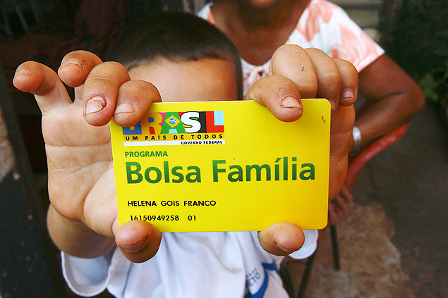 Família mostra cartão do benefício do Bolsa Família