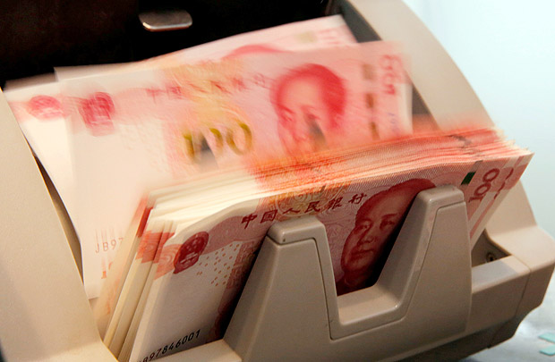 Notas de 100 yuanes em mquina de contar dinheiro em Pequim, China