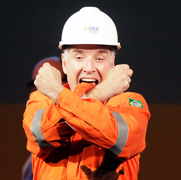 Brazilian billionaire Eike Batista (L), CEO of EBX Group, gestures to the audience during a ceremony in celebration of the start of oil production of OGX, his oil and gas company, at the Superport Industrial Complex of Acu in Sao Joao da Barra in Rio de Janeiro in this April 26, 2012 file photo. As Batista's EBX industrial empire crumbles, it increasingly resembles his most visible accomplishment, the Port of Acu. In other words, a pile of sand in the middle of a swamp. To build the $2 billion iron ore and oil terminal, shipyard and industrial park 300 kilometers (190 miles) north of Rio de Janeiro, the world's largest dredging ship cut through the beach and dug 13 kilometers (8 miles) of docks out of dune and marsh. To keep tenants dry, the sandy waste is being piled as much as 15 meters over the surrounding flood plain. Picture taken April 26, 2012. To match Analysis BRAZIL-BATISTA/ REUTERS/Ricardo Moraes/Files (BRAZIL - Tags: ENERGY BUSINESS) ORG XMIT: RJO89 ***FOTO EM ARTE E NÃO INDEXADA***
