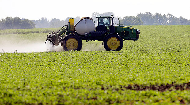 Mquina agrcola faz pulveriazao de soja, em Granger (EUA). *** FILE - This July 11, 2013, file photo shows Blake Beckett of West Central Cooperative as he sprays a soybean field, in Granger, Iowa. Faced with tougher and more resistant weeds, corn and soybean farmers are anxiously awaiting government decisions on a new version of a popular herbicide _ and on genetically modified seeds to grow crops designed to resist it. The Environmental Protection Agency is expected to rule in the fall of 2014 on Dow AgroSciences’ application to market Enlist, a new version of the 2,4-D herbicide that’s been around since the 1940s.(AP Photo/Charlie Neibergall, File)