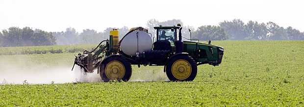 Mquina agrcola faz pulveriazao de soja, em Granger (EUA). *** FILE - This July 11, 2013, file photo shows Blake Beckett of West Central Cooperative as he sprays a soybean field, in Granger, Iowa. Faced with tougher and more resistant weeds, corn and soybean farmers are anxiously awaiting government decisions on a new version of a popular herbicide _ and on genetically modified seeds to grow crops designed to resist it. The Environmental Protection Agency is expected to rule in the fall of 2014 on Dow AgroSciences' application to market Enlist, a new version of the 2,4-D herbicide that's been around since the 1940s.(AP Photo/Charlie Neibergall, File)