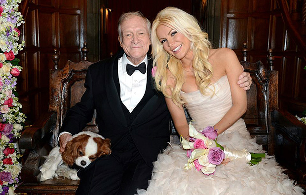 ORG XMIT: SIN102 Octogenarian Playboy founder Hugh Hefner poses with his bride Crystal Harris and dog Charlie at their New Year Eve wedding at the Playboy Mansion in Beverly Hills, California in this handout photo taken on December 31, 2012. Hefner briefly swapped his iconic silk pajamas for a tuxedo to marry Harris, the one-time "runaway bride" who followed through this time at the New Year's Eve wedding. The couple tied the knot more than a year after their planned 2011 wedding was scuttled when Harris got cold feet. REUTERS/Elayne Lodge/PEI/Handout (UNITED STATES - Tags: ENTERTAINMENT MEDIA TPX IMAGES OF THE DAY) FOR EDITORIAL USE ONLY. NOT FOR SALE FOR MARKETING OR ADVERTISING CAMPAIGNS. THIS IMAGE HAS BEEN SUPPLIED BY A THIRD PARTY. IT IS DISTRIBUTED, EXACTLY AS RECEIVED BY REUTERS, AS A SERVICE TO CLIENTS. NO ARCHIVES. NO SALES