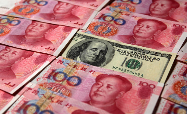 ORG XMIT: PEK03 A U.S. $100 banknote is placed next to 100 yuan banknotes in this picture illustration taken in Beijing in this October 16, 2010 file photo. China took a milestone step in turning the yuan into a global currency on April 14, 2012, by doubling the size of its trading band against the dollar, pushing through a crucial reform that further liberalises its nascent financial markets. REUTERS/Petar Kujundzic/Files (CHINA - Tags: BUSINESS POLITICS)