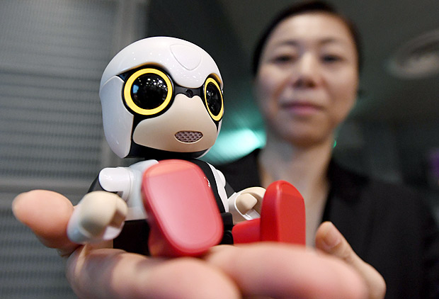 This picture taken on September 27, 2016 shows a Toyota employee displaying the company's new communication robot 'Kirobo Mini' during a press preview in Tokyo. Equipped with artificial intelligence and a built-in camera, the robot is capable of recognising the face of the person speaking to him and responding in unscripted conversation or even starting a chat. / AFP PHOTO / TOSHIFUMI KITAMURA ORG XMIT: KIT027