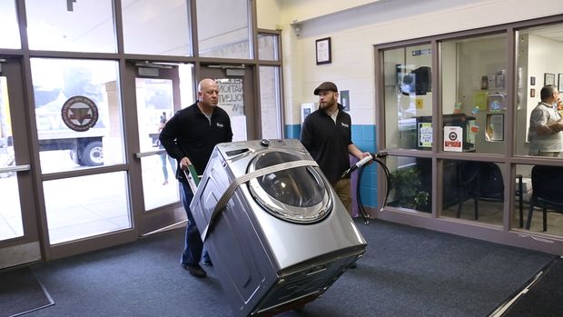 Funcionrios entregam mquina de lavar doada pela Whirlpool em colgio dos EUA