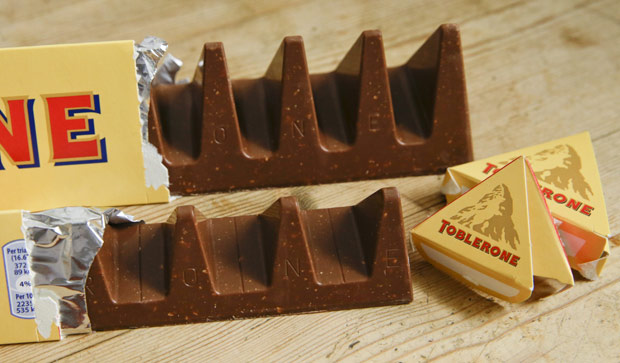 In this photo illustration two bars of the Toblerone Swiss chocolate are shown, at front is the new style 150 gram bar showing the reduction in triangular pieces, in the background is the older style 360 gram bar, pictured in London, Tuesday, Nov. 8, 2016. More valleys, fewer chocolate peaks: The maker of Toblerone Swiss chocolate says it's widened the spaces in its iconic, triangle-array bars for some discount shops in Britain to keep prices down. Mondelez International says the move aims to meet pricing targets by customer Poundland and other discount retailers, and has nothing to do with Britain's vote to leave the European Union. (AP Photo/Alastair Grant) ORG XMIT: LON111