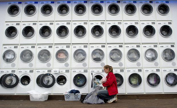  People do their laundry at a wall of washing machines and dryers at a city beach near the main station in Berlin on September 7, 2011. The German home appliance firm Siemens hosts until September 10, 2011 the free wash and dry service for tourists and local residents as promotional event during the IFA consumer electronics fair running until September 7, 2011. AFP PHOTO / ODD ANDERSEN