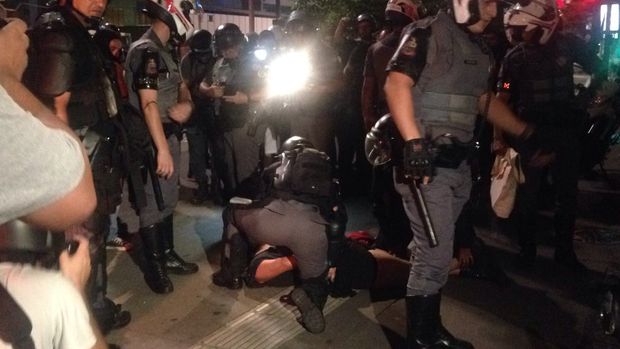 Policiais prendem uma menina entre os manifestantes na avenida Paulista