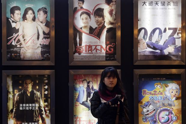 Mulher  frente de cartazes de filmes em Xangai, na China