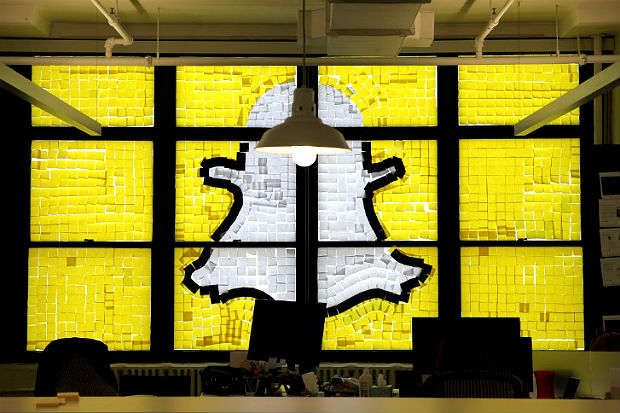 Snapchat logo image created with Post-it notes is seen in the windows of Havas Worldwide offices at 200 Hudson street in lower Manhattan, New York during 